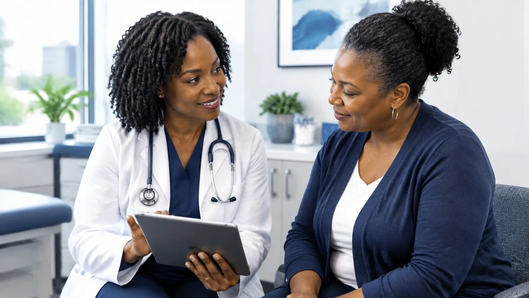 African American physician reviewing care with an African American adult patient in a primary care exam room